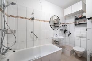 a bathroom with a tub and a toilet and a sink at Ferienwohnung Krause Dachgeschoss in Wilhelmshaven +15 photos