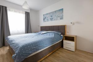 a bedroom with a bed and a nightstand and a window at Ferienhaus Nr 4, Kategorie Premium L, Feriendorf Hochbergle, Allgäu in Lechbruck