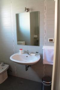 een badkamer met een witte wastafel en een spiegel bij Apartments Residence L'Ulivo in Rovinj +42 foto's