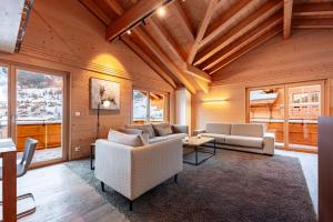 グリンデルワルトにあるPrival - Majestic Peak 3br Chaletのソファとテーブルのあるリビングルーム