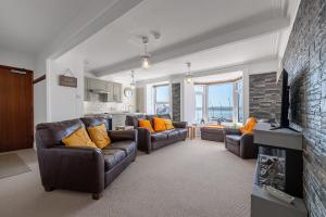 a living room with two couches and a fireplace at Spacious 3 Bedroom Sea View Flat in Aberdyfi