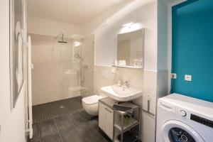 a bathroom with a toilet sink and a washing machine at ANER 4 Design Apartment Zoe in Dresden +18 photos