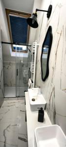 a white bathroom with a sink and a mirror at Luksuswy Domek Fantazja z sauną i kominkiem przy stoku narciarskim in Karpacz +24 photos