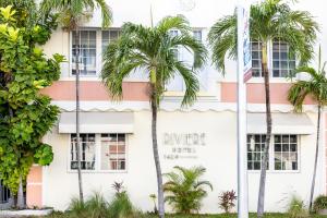 un edificio con palmeras delante en Riviere South Beach Hotel, en Miami Beach