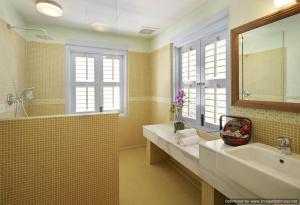 uma casa de banho com um grande lavatório e um espelho em 23 Love Lane Hotel em George Town