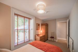 a bedroom with a bed and a dresser and a window at Spacious 3 Bedroom Sea View Flat in Aberdyfi