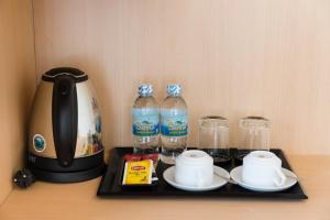 a tray with a tea kettle and two bottles of water at AQua Hotel & Spa in Nha Trang