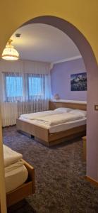 ジアーノ・ディ・フィエンメにあるHotel Villa Jolandaのベッドルーム1室(ベッド2台付)、アーチ型の間取り