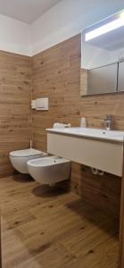 ジアーノ・ディ・フィエンメにあるHotel Villa Jolandaの洗面台、トイレ、鏡のあるバスルーム