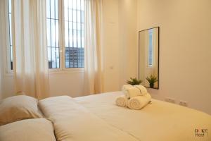 a bedroom with a bed with towels on it at Duke 5torres Apartments in Madrid