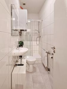Un baño blanco con inodoro y lavabo. en stayVision LS1 Wohnung 8 - 1 bedroom - 4 guests - top Wi-Fi, en Wuppertal 21 fotos más