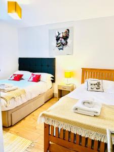 a bedroom with two beds and a table at Blueberry Cottage - Lower Mill Estate in Somerford Keynes +51 photos