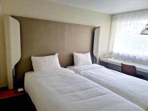 Postel nebo postele na pokoji v ubytování Campanile Hotel Chantilly