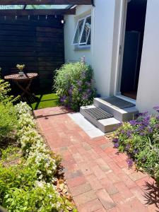 a brick walkway outside of a house with flowers at Stellenbosch Serenity in Stellenbosch
