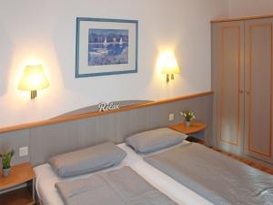 a bedroom with two beds and two lights on the wall at Ferienhaus Nr 5, Kategorie Komfort, Feriendorf Hochbergle, Allgäu in Lechbruck