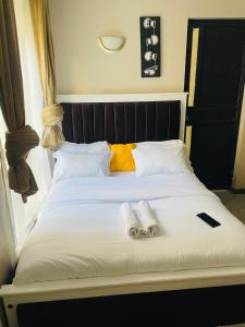 a bed with two pairs of slippers sitting on it at A modern affordable stylish bedsitter centrally located in nairobi in Nairobi