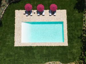 an overhead view of a swimming pool with red umbrellas at Villa Mandorla by My Villa Collection in Badia A Passignano