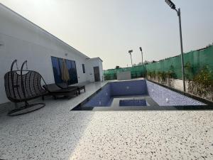 una piscina con un banco y un edificio en Dhaulidhar Farms, en Greater Noida