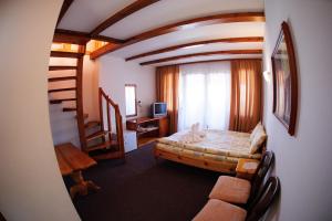 a room with a bed and a spiral staircase at Family Hotel Nadejda in Bansko