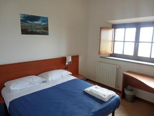 a bedroom with a blue bed and a window at Trasimeno Nature house in Castiglione del Lago