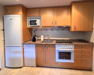 a kitchen with a white refrigerator and a microwave at BPirineos-Casa Chuanina in Benasque