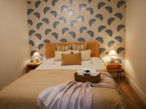 a bedroom with a large bed with a patterned wall at Vivienda pleno corazón de la ciudad, As rías in A Coruña