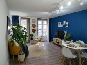 a living room with a table and a blue wall at Vivienda pleno corazón de la ciudad, As rías in A Coruña