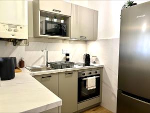 a kitchen with a stainless steel refrigerator and a sink at KLEBER- charmant T2 proche gare in Saint-Brieuc +9 photos