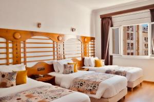 A bed or beds in a room at Hôtel Rembrandt