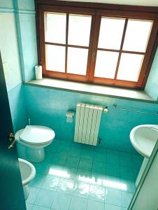 a bathroom with a toilet and a sink and a window at Trasimeno Nature house in Castiglione del Lago