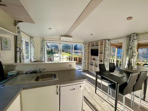 a kitchen with a sink and a table with chairs at Camping du Valentin in Laruns