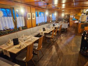 a restaurant with tables and chairs in a room at Alemannenhof Hotel Engel in Rickenbach