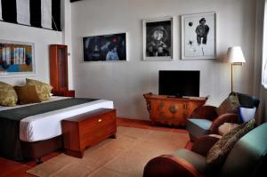 a bedroom with a bed and a tv and a couch at 23 Love Lane Hotel in George Town