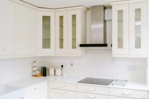 a white kitchen with white cabinets and a stove at City Centre - Free Parking - 2 Bedroom in Belfast