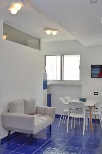 a living room with a couch and a table and chairs at L' Orologio del Campanile with terrace in Minori