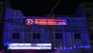 a building with blue lights and a sign on it at Shri Ramnarayan Homestay in Prayagraj