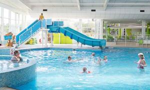 a group of people swimming in a swimming pool at Lodge Retreat 4 - Haggerston Castle in Berwick-Upon-Tweed