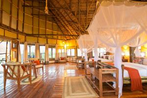 a room with several beds and tables and windows at Aardvark Safari Lodge in Rubirizi