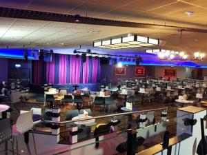 a large room with tables and chairs and purple curtains at Lodge Retreat 4 - Haggerston Castle in Berwick-Upon-Tweed