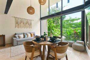 a living room with a wooden table and chairs at Loft Hermosa at Tulum's Mistiq Temple II Beaches in Tulum