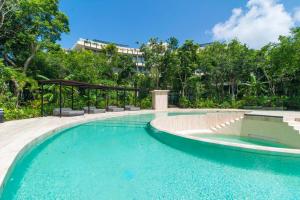 a swimming pool in a resort with trees at Loft Hermosa at Tulum's Mistiq Temple II Beaches in Tulum