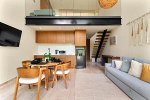 a kitchen and living room with a table and a couch at Loft Hermosa at Tulum's Mistiq Temple II Beaches in Tulum