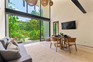 a living room with a table and a couch at Loft Hermosa at Tulum's Mistiq Temple II Beaches in Tulum
