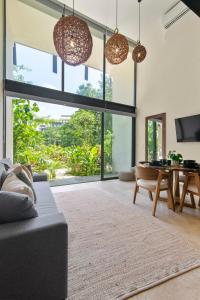 a living room with a couch and a table at Loft Hermosa at Tulum's Mistiq Temple II Beaches in Tulum