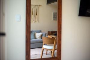 a mirror reflecting a living room with a couch and a chair at Loft Hermosa at Tulum's Mistiq Temple II Beaches in Tulum