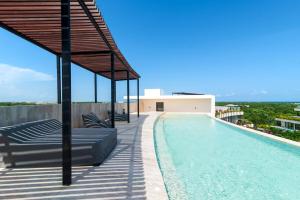 a swimming pool on the roof of a house at Loft Hermosa at Tulum's Mistiq Temple II Beaches in Tulum
