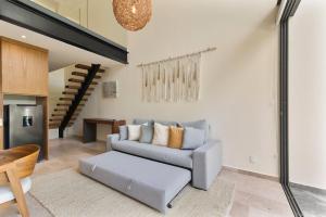 a living room with a couch and a table at Loft Hermosa at Tulum's Mistiq Temple II Beaches in Tulum