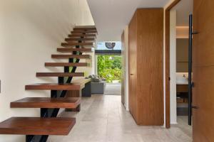 a staircase in a house with wooden steps at Loft Hermosa at Tulum's Mistiq Temple II Beaches in Tulum