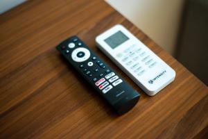 two remote controls and a cell phone sitting on a table at Loft Hermosa at Tulum's Mistiq Temple II Beaches in Tulum
