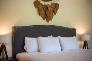 a bedroom with a bed with white pillows and two lamps at Loft Hermosa at Tulum's Mistiq Temple II Beaches in Tulum